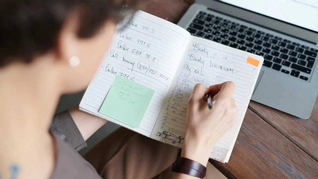 An individual plans a business in a notebook